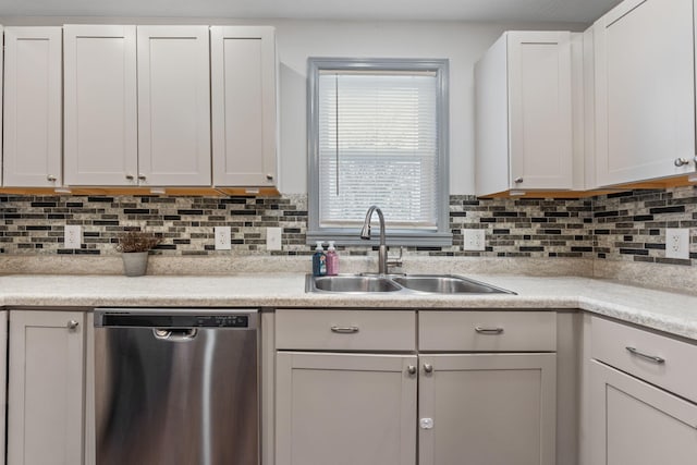 kitchen with a sink, tasteful backsplash, stainless steel dishwasher, and light countertops