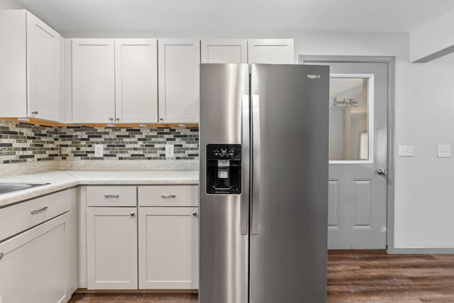 kitchen featuring backsplash, dark wood-style flooring, stainless steel refrigerator with ice dispenser, and light countertops