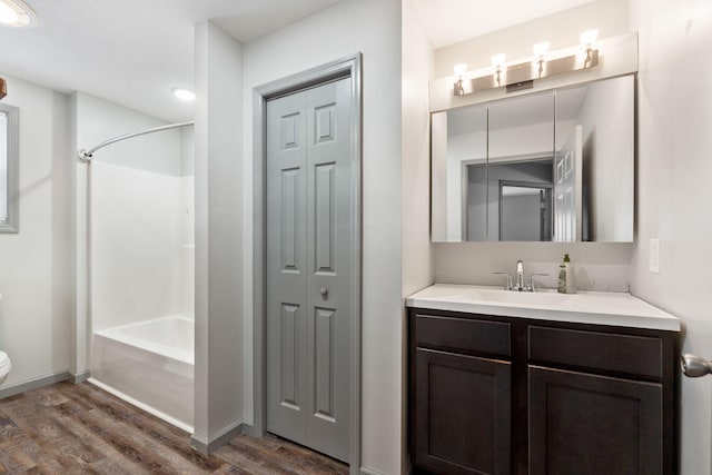 full bathroom with vanity, toilet, bathing tub / shower combination, and wood finished floors