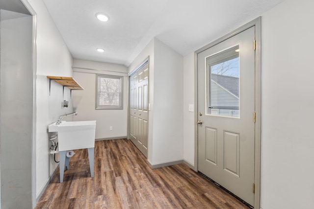 doorway with wood finished floors and baseboards