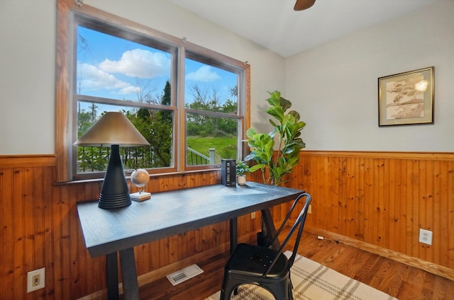 office area featuring a healthy amount of sunlight, a wainscoted wall, and wood walls