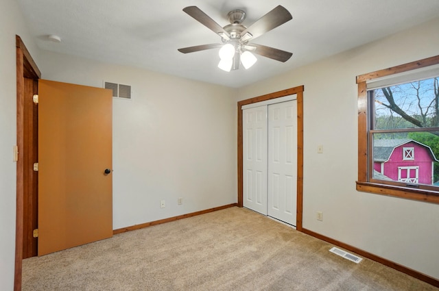 unfurnished bedroom with carpet floors, baseboards, and visible vents