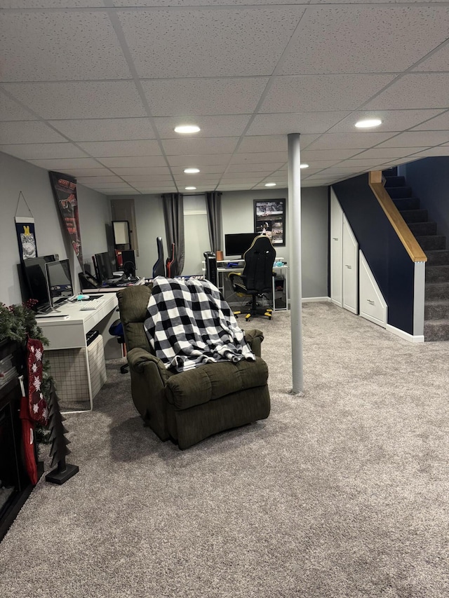 carpeted living room featuring a drop ceiling