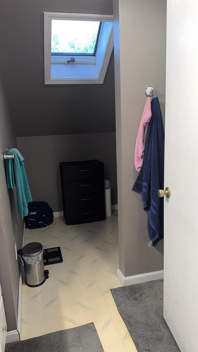 bathroom featuring vaulted ceiling with skylight