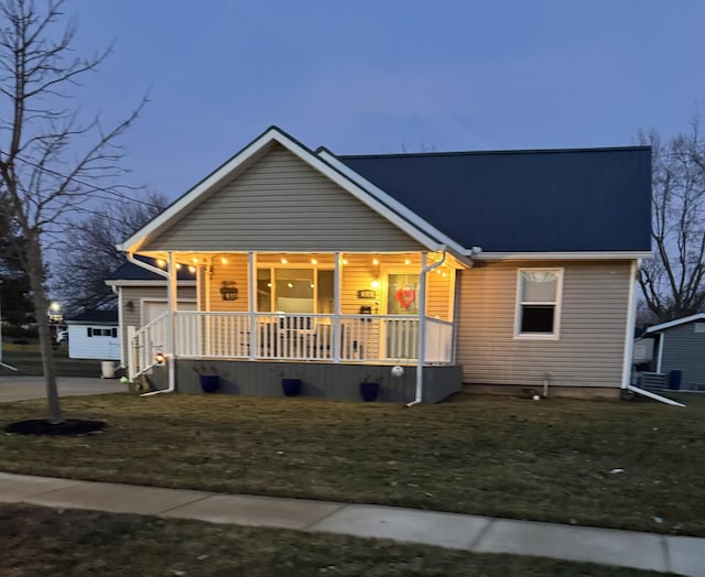 view of front facade featuring covered porch and a lawn