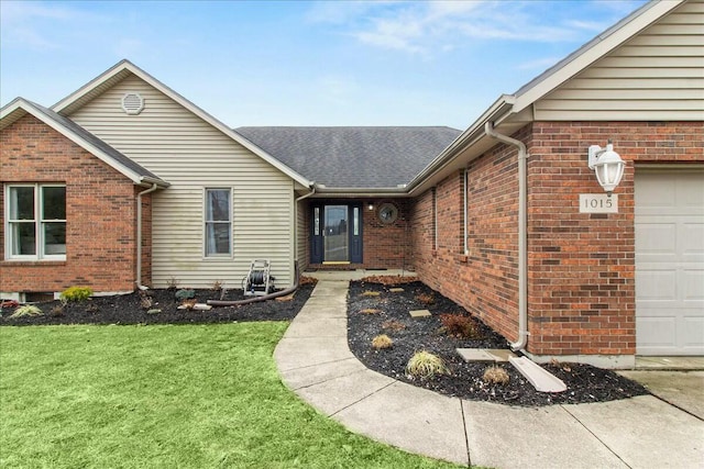 entrance to property with a garage, brick siding, roof with shingles, and a yard