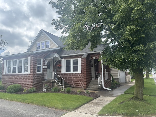 217 S 2nd St, Coldwater, OH 45828 - bungalow with brick siding, a front lawn, and a shingled roof