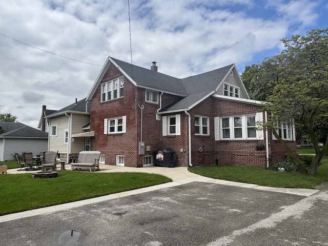 217 S 2nd St, Coldwater, OH 45828 - rear view of house with a lawn, brick siding, a chimney, and a patio area