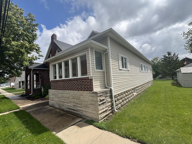 217 S 2nd St, Coldwater, OH 45828 - view of side of home with a chimney, a yard, and brick siding