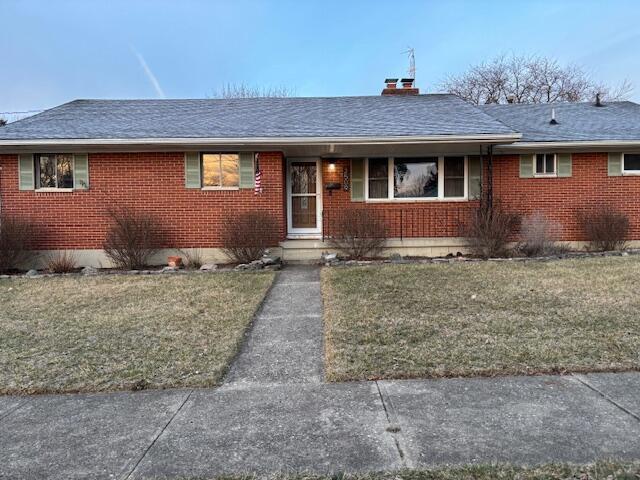 ranch-style home with a front lawn