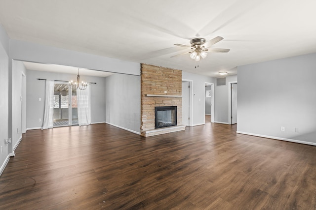 unfurnished living room featuring a stone fireplace, dark hardwood / wood-style flooring, and ceiling fan with notable chandelier