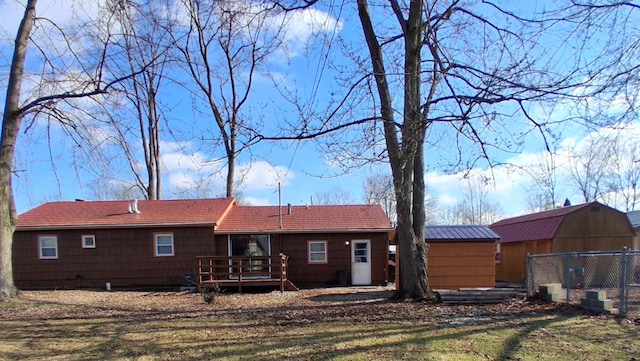 back of house featuring a wooden deck and an outdoor structure