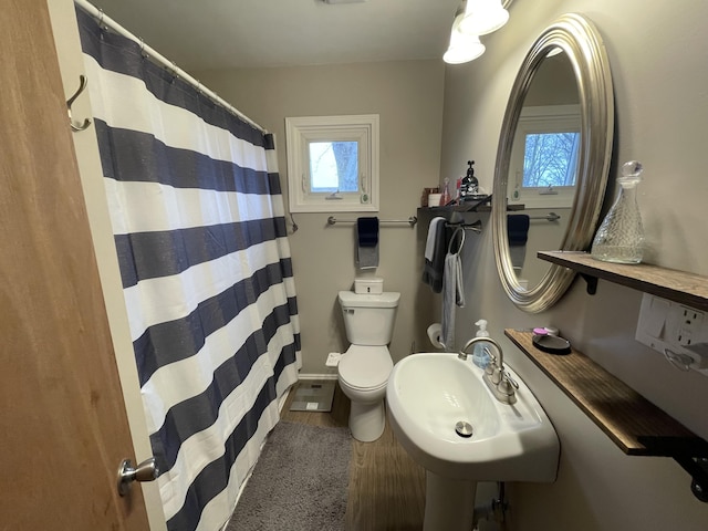 bathroom featuring a sink, toilet, curtained shower, and wood finished floors