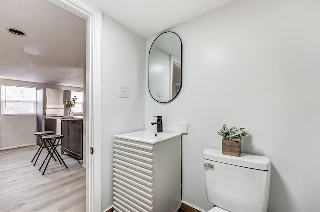 bathroom with vanity, hardwood / wood-style flooring, and toilet