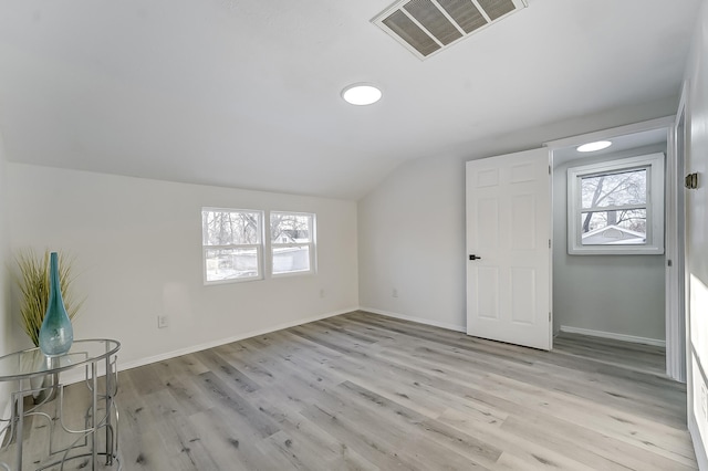 additional living space with vaulted ceiling, plenty of natural light, and light wood-type flooring