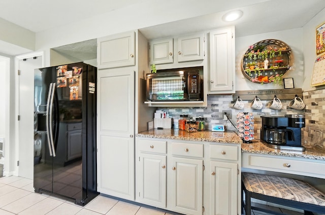 115 Deer Run Rd, Urbana, OH 43078 - kitchen with black appliances, backsplash, light tile patterned flooring, light stone countertops, and white cabinetry