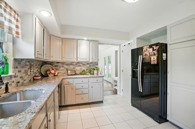 115 Deer Run Rd, Urbana, OH 43078 - kitchen featuring black refrigerator with ice dispenser, decorative backsplash, light tile patterned floors, and light stone countertops