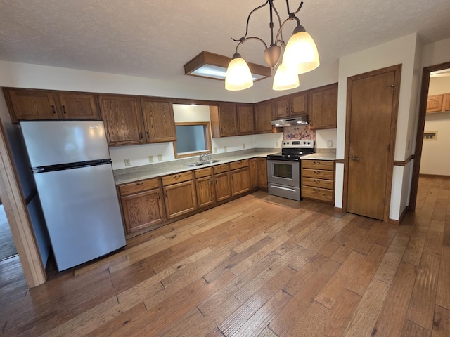 6708 Hillside Ct, Celina, OH 45822 - kitchen with appliances with stainless steel finishes, under cabinet range hood, light wood-style floors, light countertops, and a textured ceiling