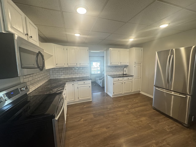 5319 Karafit Rd, Celina, OH 45822 - kitchen with appliances with stainless steel finishes, a paneled ceiling, white cabinetry, dark wood-type flooring, and tasteful backsplash