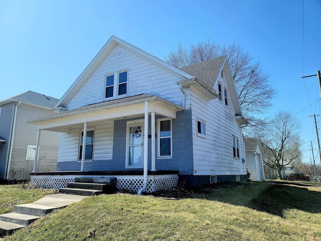 bungalow-style home featuring a porch, a front yard, and roof with shingles