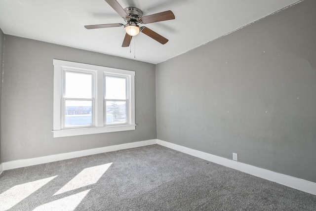 carpeted spare room with baseboards and ceiling fan