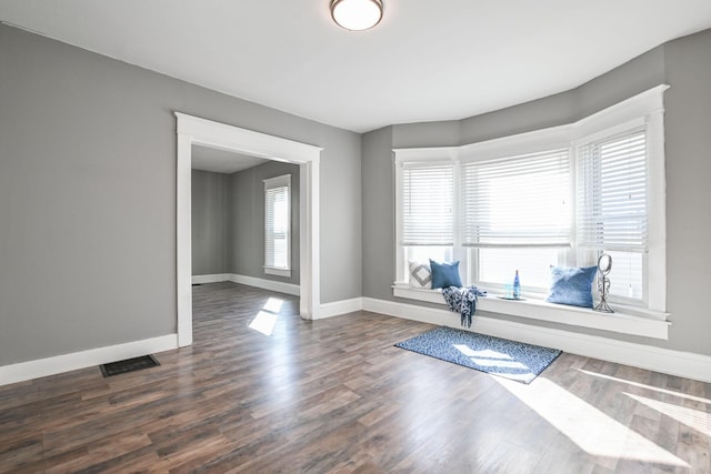 exercise area featuring visible vents, baseboards, and dark wood finished floors