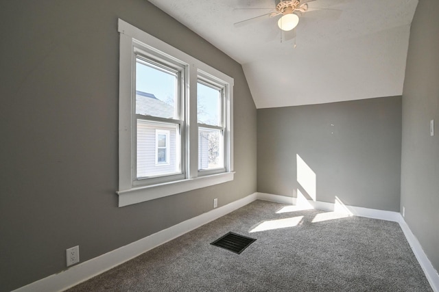 additional living space with lofted ceiling, carpet flooring, baseboards, and visible vents