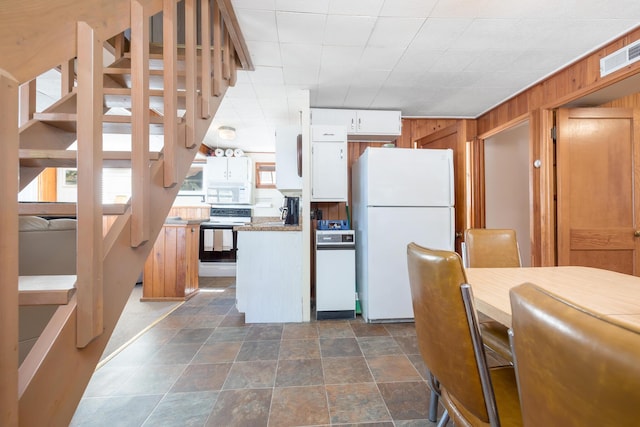 7535 Township Rd 269, Russells Point, OH 43348 - kitchen featuring white appliances, wooden walls, white cabinetry, and dark stone finish floors