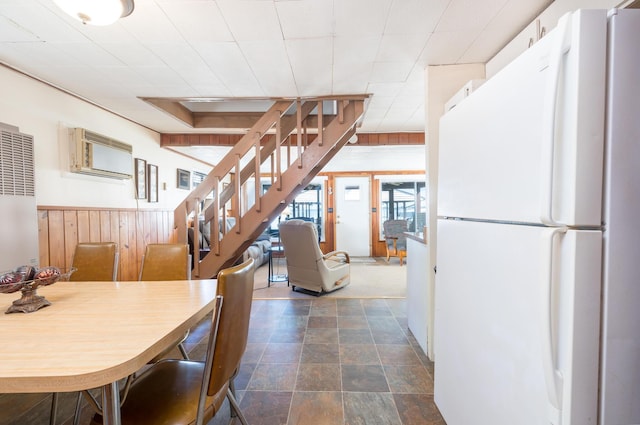 7535 Township Rd 269, Russells Point, OH 43348 - dining area featuring stairs, dark stone finish floors, wooden walls, a heating unit, and wainscoting