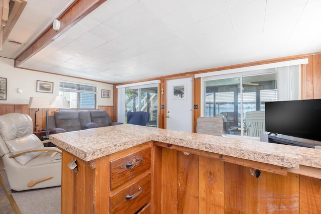 7535 Township Rd 269, Russells Point, OH 43348 - kitchen with light countertops, open floor plan, wooden walls, brown cabinetry, and a wainscoted wall