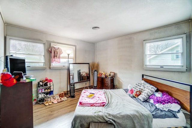 bedroom with visible vents and wood finished floors