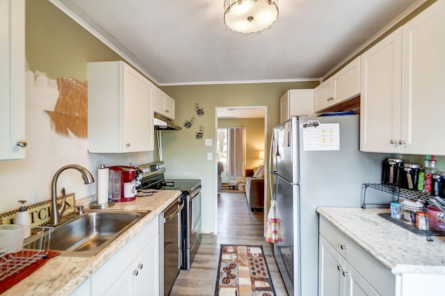 kitchen with under cabinet range hood, stainless steel appliances, a sink, white cabinetry, and light wood finished floors