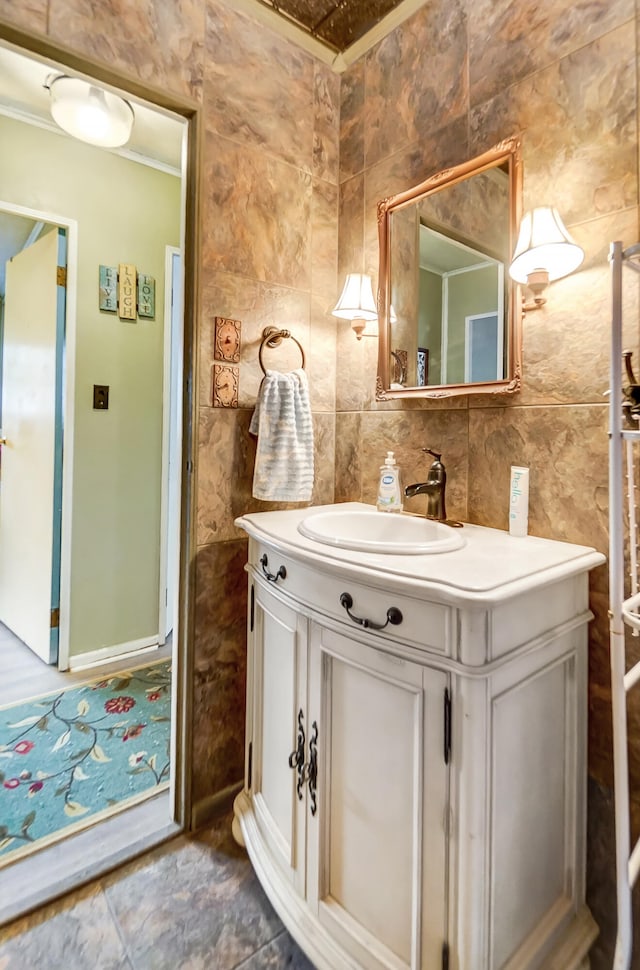 bathroom featuring ornamental molding, backsplash, vanity, and tile walls