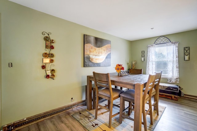 dining space featuring baseboards and wood finished floors