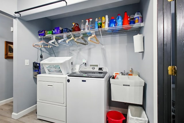 1264 Pheasant Run Unit 74, Springfield, OH 45503 - laundry room featuring washer and dryer, baseboards, and light wood-style flooring
