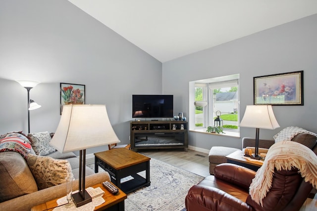 1264 Pheasant Run Unit 74, Springfield, OH 45503 - living area featuring wood finished floors, high vaulted ceiling, and baseboards