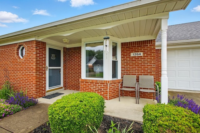 1264 Pheasant Run Unit 74, Springfield, OH 45503 - property entrance featuring brick siding, a garage, and covered porch
