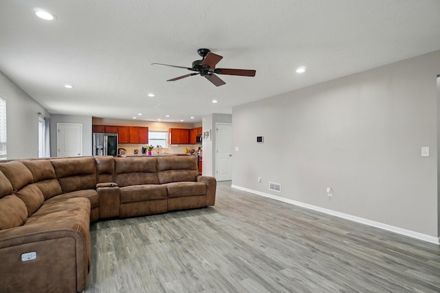 1087 Ayrshire Dr, Columbus, OH 43207 - living room featuring ceiling fan, recessed lighting, baseboards, light wood finished floors, and healthy amount of natural light