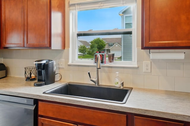 1087 Ayrshire Dr, Columbus, OH 43207 - kitchen featuring stainless steel dishwasher, a sink, light countertops, and tasteful backsplash