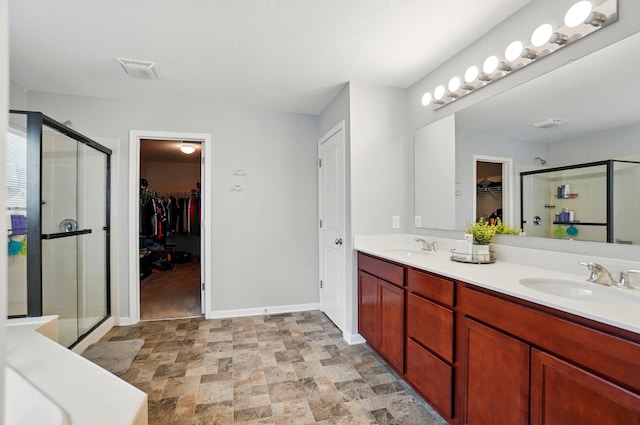 1087 Ayrshire Dr, Columbus, OH 43207 - full bathroom with a stall shower, double vanity, stone finish floors, and a spacious closet