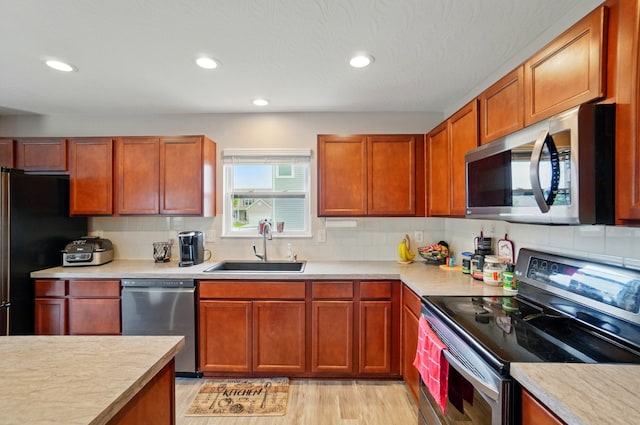 1087 Ayrshire Dr, Columbus, OH 43207 - kitchen with stainless steel appliances, a sink, light countertops, decorative backsplash, and recessed lighting