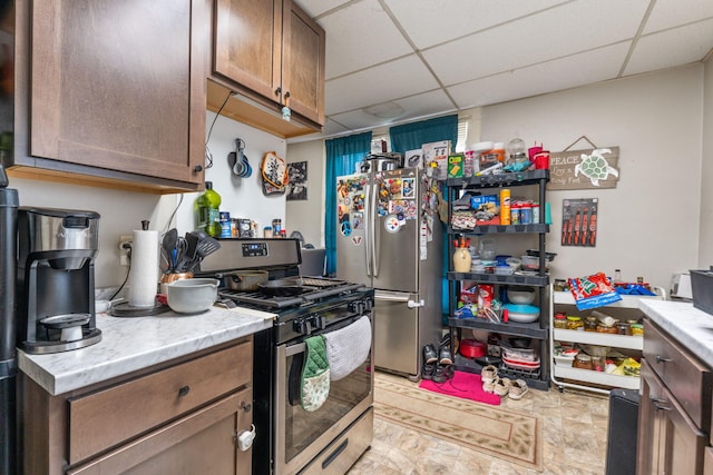 kitchen featuring appliances with stainless steel finishes, light countertops, and a paneled ceiling