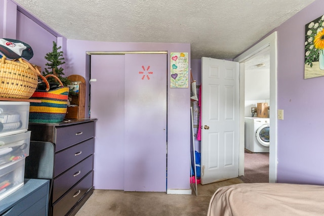 carpeted bedroom featuring washer / clothes dryer, a textured ceiling, and a closet