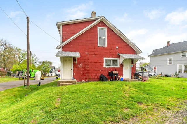 rear view of house with a yard and a chimney