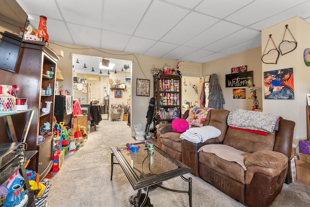 carpeted living room with a paneled ceiling