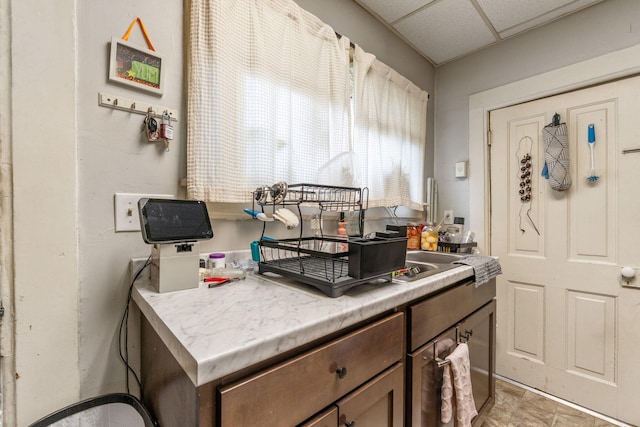 kitchen featuring light countertops and a drop ceiling