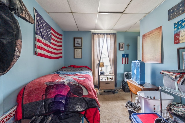 bedroom featuring a drop ceiling and carpet floors