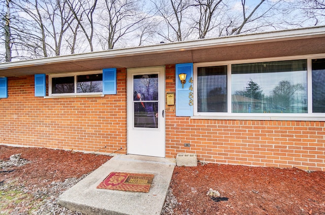 view of exterior entry with brick siding