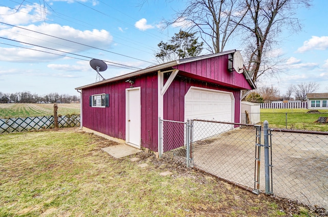 detached garage featuring a gate, fence, and driveway