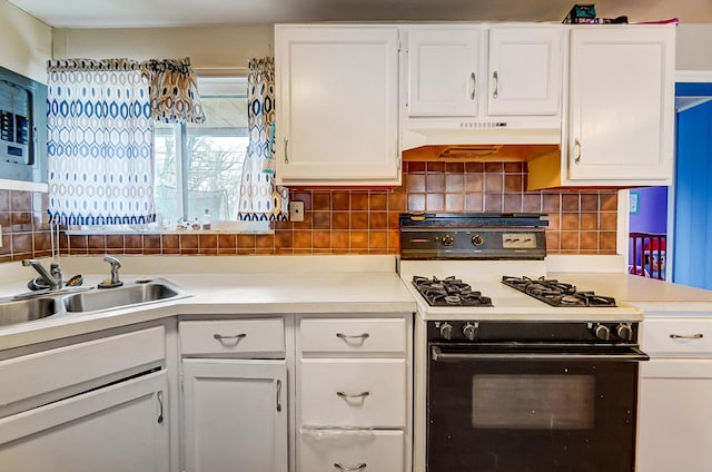 kitchen with under cabinet range hood, white cabinetry, a sink, and range with gas cooktop